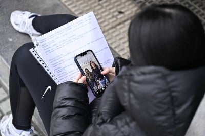 A teenager scrolls through social media on her phone. (Photo by ANDER GILLENEA / AFP) AFP file photo for illustration purpose only