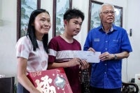 YKM chairman Datuk Seri Ismail Sabri Yaakob (right) presents a contribution to Loke Kim Yen, 51 (left) and her son Soh Zhe Hong, 18 (middle) during the Ziarah Kasih programme in conjunction with the Chinese New Year celebration in Larkin today. - Photo by Bernama