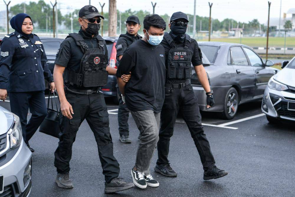 Factory worker Amirul Shafiq Shamshul Zahari was charged in the Magistrate’s Court here today with the murder of his biological mother, a bank executive, earlier this month. Photo by Bernama