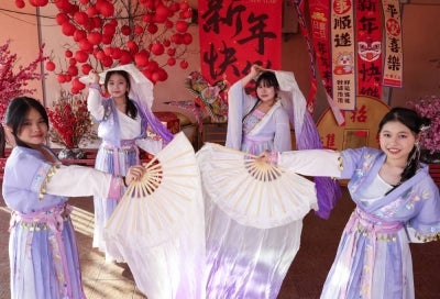 Fan dance team members Loo Yu Jie, 16, (front left) and Chong Jia Eng, 14, (standing right), together with teammates Chloe Eng Szen, 14, (standing left) and Liew Yu Xin, 16, (right), rehearse in preparation for a performance in conjunction with Chinese New Year at the temple grounds in Kampung Baru, Gua Musang. - Bernama photo