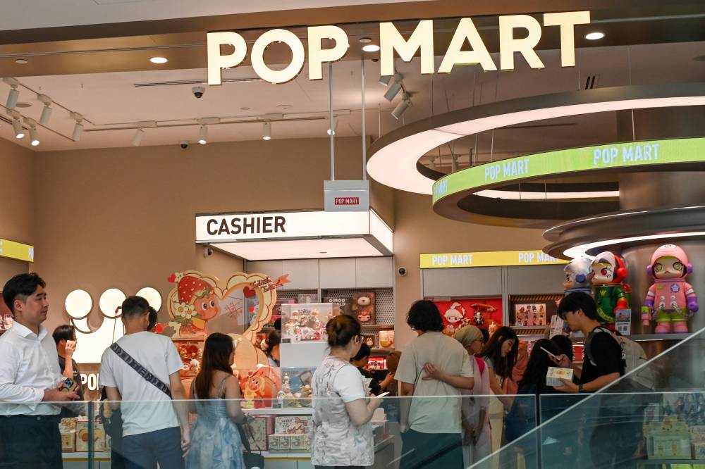 People visit a Pop Mart shop that sells "blind box" products at a mall in Singapore on Feb 13, 2026. - (Photo by ROSLAN RAHMAN / AFP)
