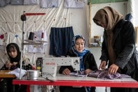 This photograph taken on January 20, 2026 shows Afghan women embroidering scarves and clothes at a boutique in Bamiyan. With women banned from most jobs in Afghanistan, an embroidery boutique run by 22-year-old Rahima Alavi is a surprising and treasured sight in Bamiyan. Alavi is one of more than five million people who returned to the country since 2023 from neighbouring Iran and Pakistan, which have been pushing back Afghans after decades of hosting them. (Photo by Wakil KOHSAR / AFP)
