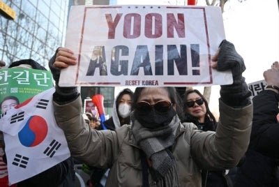 Supporters of South Korea's impeached former president Yoon Suk Yeol react as they watch a live stream of Yoon's trial on his insurrection charges near the Seoul Central District Court in Seoul on Feb 19, 2026. - (Photo by Jung Yeon-je / AFP)
