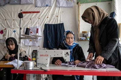 This photograph taken on January 20, 2026 shows Afghan women embroidering scarves and clothes at a boutique in Bamiyan. With women banned from most jobs in Afghanistan, an embroidery boutique run by 22-year-old Rahima Alavi is a surprising and treasured sight in Bamiyan. Alavi is one of more than five million people who returned to the country since 2023 from neighbouring Iran and Pakistan, which have been pushing back Afghans after decades of hosting them. (Photo by Wakil KOHSAR / AFP)