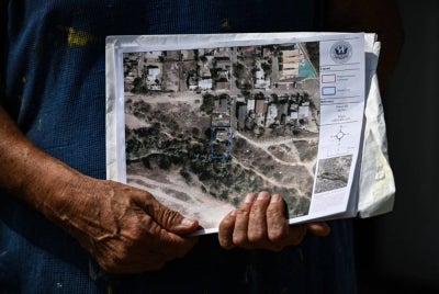 US citizen Antonio Rosales Jr. shows a map of his property where the US government plans to build a border wall, in Laredo, Texas, on Feb 20, 2026. - (Photo by RONALDO SCHEMIDT / AFP)