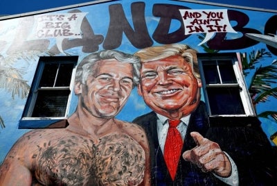 A mural titled "Island Boys" by artist Scott Marsh is seen on a building wall in Sydney on Feb 24, 2026, depicting Jeffrey Epstein alongside several high-profile figures referenced in the recently released Epstein documents. - (Photo by SAEED KHAN / AFP)