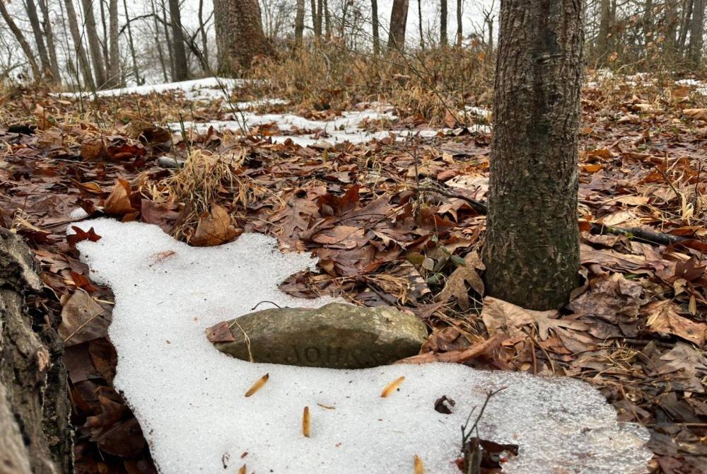 An abandoned 19th-century grave is seen on the grounds of the House of Reformation for Colored Children, a closed down segregated juvenile detention facility that operated in the late 19th and early 20th century, in Cheltenham, Maryland, on Feb 17, 2026. - (Photo by VICTORIA LAVELLE / AFP)