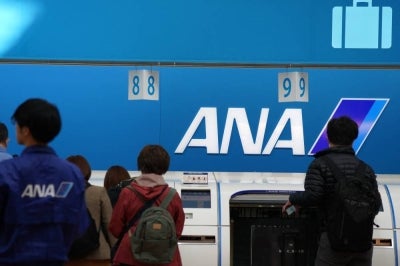 Passengers check in their luggage at the ANA baggage check-in counter at Haneda Airport in Tokyo on November 29, 2025. (Photo by Kazuhiro NOGI / AFP)