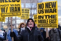 A person holds placards and chants slogans as they rally during a protest against US military action in Iran in New York City, on March 2, 2026. - (Photo by RYAN MURPHY / AFP)