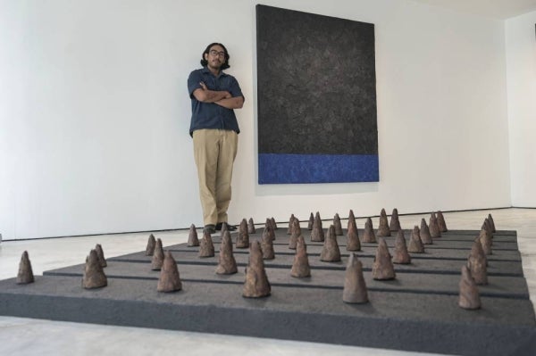 Artist Muhamat Ammar Idris poses with his artwork after the opening ceremony of the Iltizam Alir exhibition at Menara Chan recently. - Photo by Bernama