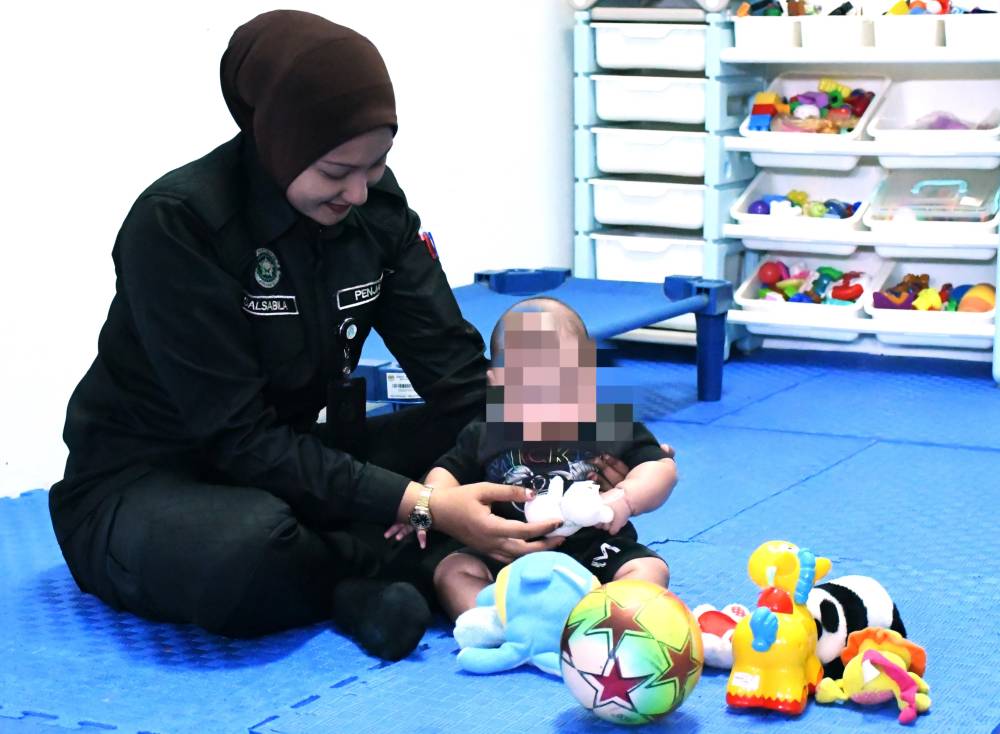 Prison staff at Bentong Prison help care for Salma's baby at the dedicated care centre provided within the facility.