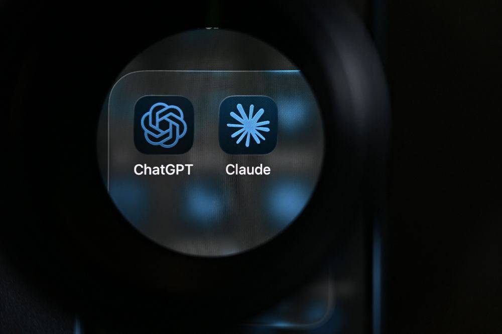 Artificial intelligence (AI) assistants ChatGPT by US Company OpenAI and Claude by US AI safety and research company Anthropic displayed on a smartphone's screen. Photo by Nicolas Tucat/AFP