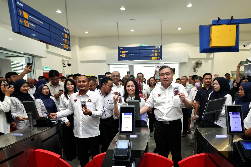 Transport Minister Anthony Loke (right), along with Deputy Communications Minister and Kulai Member of Parliament Teo Nie Ching (center), and Johor Public Works, Transport, Infrastructure, and Communications Committee Chairman Mohamad Fazli Mohamad Salleh (left), scan their MADANI Commuter cards to board the Kulai-Kempas Shuttle train at the Launch Ceremony of the Southern Shuttle Service Operations at the Kulai Railway Station. BERNAMA Photo