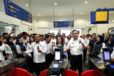 Transport Minister Anthony Loke (right), along with Deputy Communications Minister and Kulai Member of Parliament Teo Nie Ching (center), and Johor Public Works, Transport, Infrastructure, and Communications Committee Chairman Mohamad Fazli Mohamad Salleh (left), scan their MADANI Commuter cards to board the Kulai-Kempas Shuttle train at the Launch Ceremony of the Southern Shuttle Service Operations at the Kulai Railway Station. BERNAMA Photo