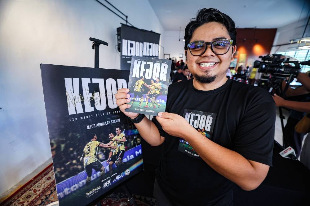 The Vocket sports journalist Meor Abdullah Syamim Meor Lod Ismail poses for a photograph at the launch of the book "KEJOR: 120 Minit Gila di Shah Alam" in Meru Raya recently. - Photo by Bernama