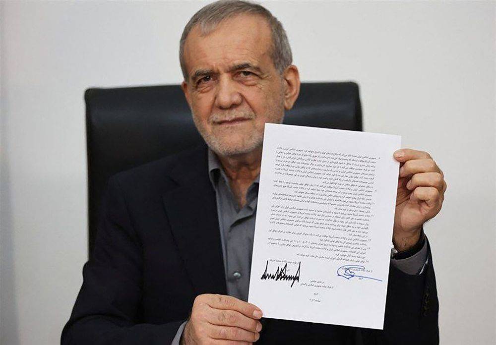 Iran's President Masoud Pezeshkian holding a document showing a memorandum of understanding he signed to end the Middle East war. Photo by Handout/IRIB/AFP