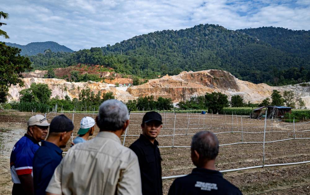 Residents observe mineral extraction activities being carried out near their homes at Rancangan Penempatan Tersusun (RPT) Batu 10 in Ulu Chepor, today. - Photo by Bernama