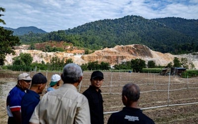 Residents observe mineral extraction activities being carried out near their homes at Rancangan Penempatan Tersusun (RPT) Batu 10 in Ulu Chepor, today. - Photo by Bernama