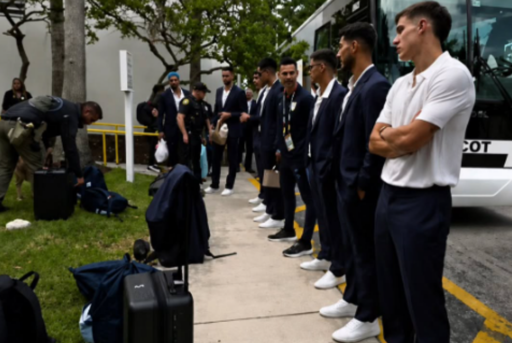 Screenshot of video footage showing clip captured members of the Uruguayan squad waiting beside their team bus while officials carried out security screenings on suitcases lined up along the roadside. - Photo: Threads/cupidfc