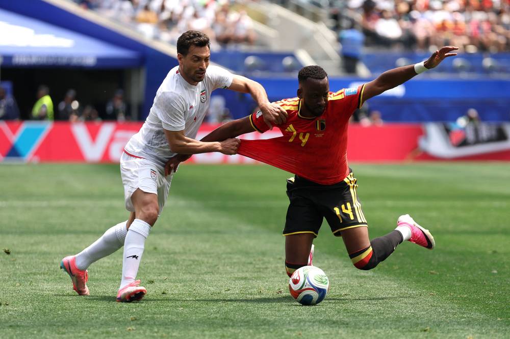 INGLEWOOD, CALIFORNIA - JUNE 21: Dodi Lukebakio #14 of Belgium is fouled by Shoja Khalilzadeh #4 of IR Iran during the FIFA World Cup 2026 Group G match between Belgium and IR Iran at Los Angeles Stadium on June 21, 2026 in Inglewood, California. (Photo by JAMIE SQUIRE / Getty Images via AFP)