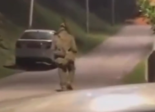 A 15-second video circulating on social media shows a man dressed in a green military-style uniform walking through a residential area while carrying a rifle. Photo: Screenshot from Threads/raranurhaliza
