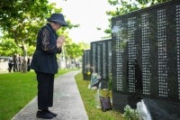 A woman prays for lost loved ones while visiting the Peace Memorial Park. AFP file photo
