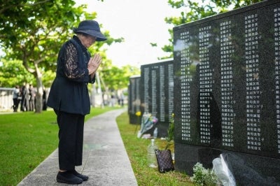A woman prays for lost loved ones while visiting the Peace Memorial Park. AFP file photo