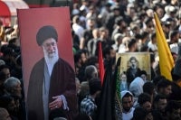 Kashmiri Shia mourners hold a portrait of Iran's late supreme leader Ayatollah Ali Khamenei during a religious procession on the seventh day of Ashura during the Islamic holy month of Muharram in Srinagar on June 23, 2026. - (Photo by TAUSEEF MUSTAFA / AFP)