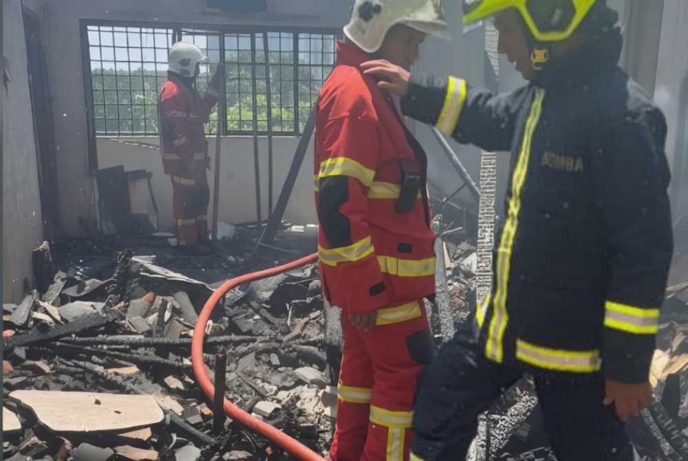 Firefighters are seen extinguishing a fire involving a unit of an apartment at Taman Pinggiran Putra here on Friday.