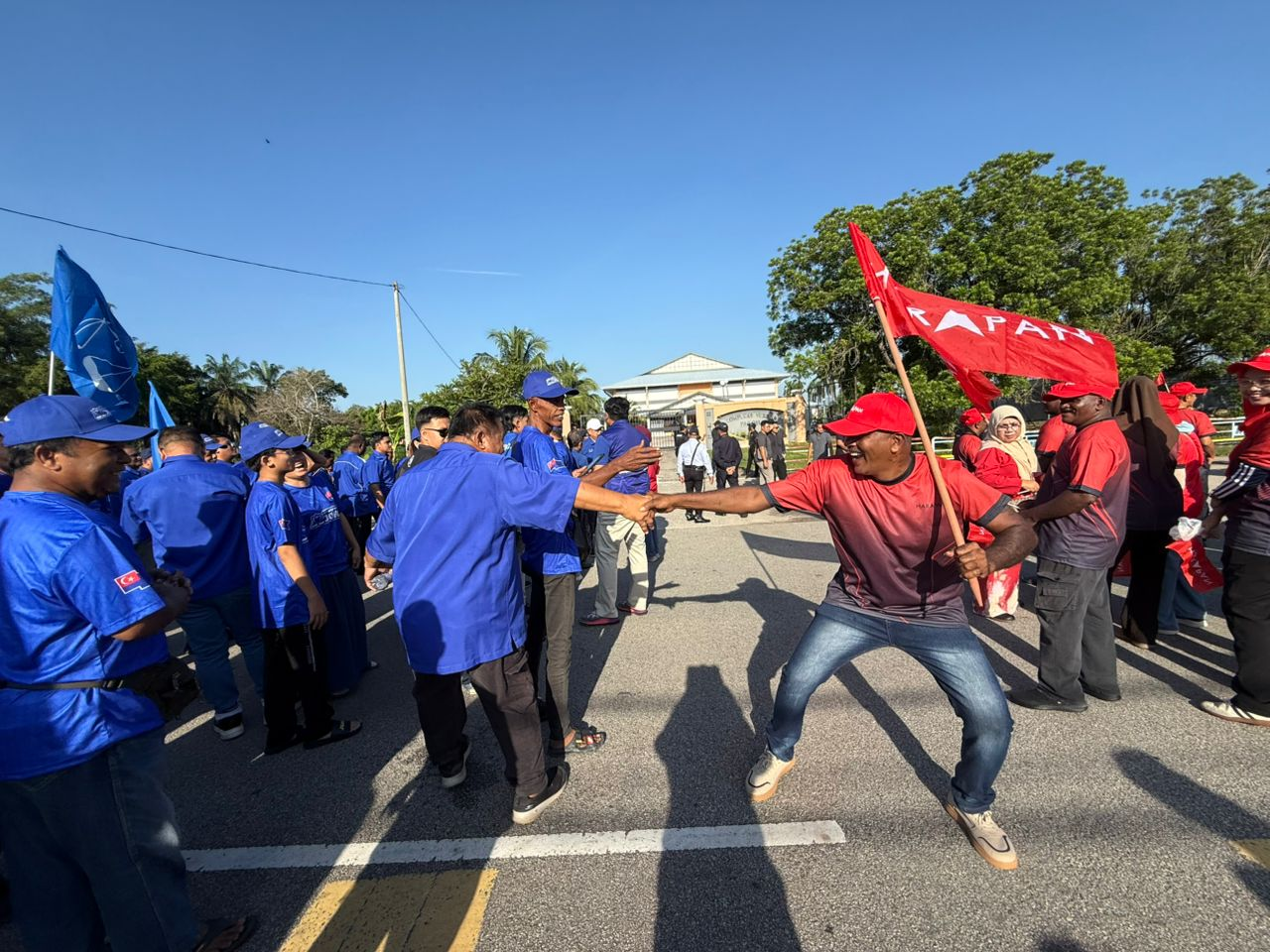 BN and PH supporters banter near the Pagoh Sports Complex, the nomination centre for Bukit Kepong seat. Photo by Norafiza Jaafar