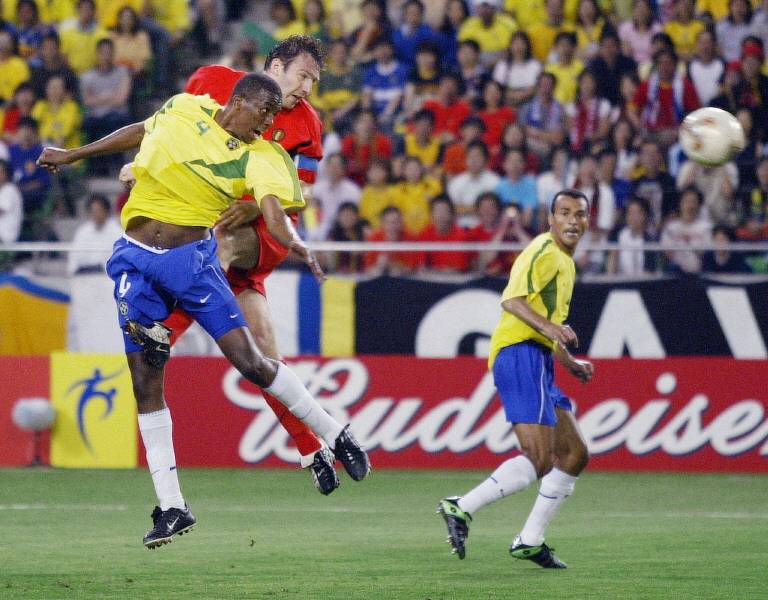 Belgian forward Marc Wilmots (C) heads at the goal, as Brazilian midfielder Roque Junior (L) and defender Cafu look on during the second round match Brazil/Belgium of the 2002 FIFA World Cup in Korea and Japan. Photo by AFP