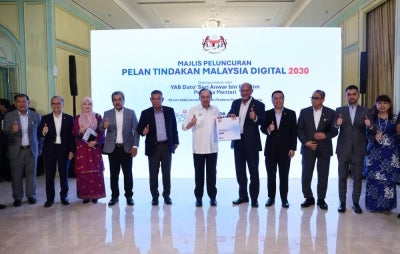 Prime Minister Datuk Seri Anwar Ibrahim (centre) poses for a commemorative photograph after receiving the Malaysia Digital 2030 Towards an AI Nation Action Plan booklet from Digital Minister Gobind Singh Deo (fifth, right) at the Launching Ceremony of the Malaysia Digital 2030 (MD2030) Action Plan at the Perdana Putra Building today. (BERNAMA photo)