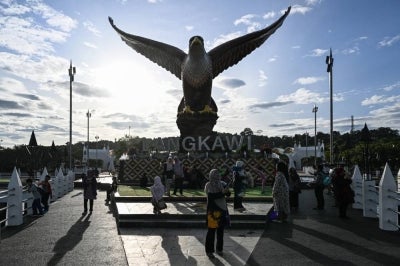 Tourists gather by the eagle statue at Dataran Lang, in Malaysia's resort island of Langkawi. AFP photo.