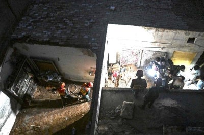 Rescue workers clear a damaged room after a tutoring centre's roof collapsed, on the outskirts of Lahore. Photo by Arif Ali/AFP