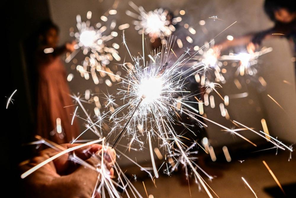 Girls light firecrackers during celebrations to mark the Sinhala and Tamil New Year in Pugoda, Sri Lanka on April 14, 2025. AFP photo
