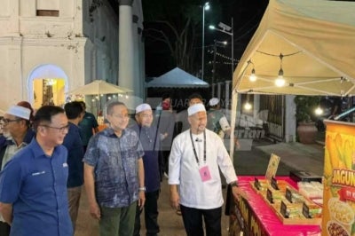 PN chairman Datuk Seri Dr Ahmad Samsuri Mokhtar (middle), Gerakan president Datuk Dr Dominic Lau (left) and PN Maharani candidate Anuar Hayan during a walkabout in Bandar Maharani on Wednesday.