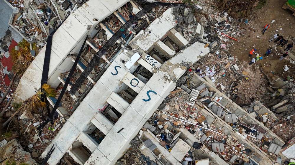 This aerial view taken on July 2, 2026 in Caraballeda in the state of La Guaira shows collapsed buildings following the June 24 twin earthquakes. - (Photo by MIGUEL MEDINA / POOL / AFP)
