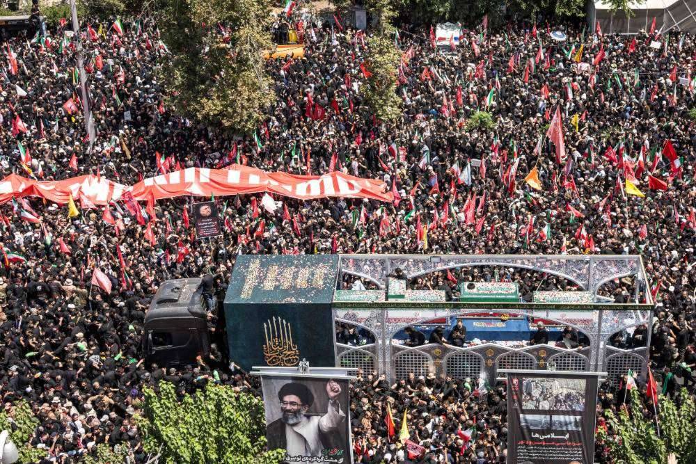 Crowds of mourners surround the convoy carrying the coffins of Iran's slain supreme leader Ali Khamenei and members of his family during a funeral procession near Azadi Square in Tehran. Photo by AFP