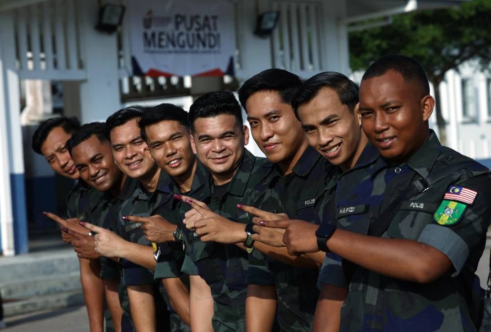 Members of the General Operations Force (GOF) show their inked fingers after casting their votes during the early voting process for the 16th Johor state election at the GOF Battalion 5 Camp in Simpang Renggam today. - Photo by Bernama