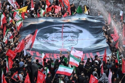 People hold up a revenge banner against the US president as they gather to mourn Iran's slain supreme leader Ayatollah Ali Khamenei at the Grand Mosalla. Photo by AFP