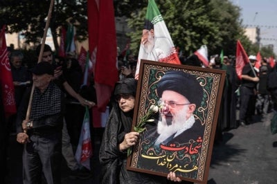 A mourner holds a portrait of Iran's late supreme leader Ayatollah Ali Khamenei (Photo by AFP) 