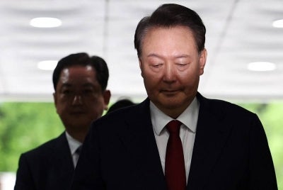 South Korea's former impeached president Yoon Suk Yeol (R) arrives at a court to attend a hearing to review his arrest warrant requested by special prosecutors in Seoul on July 9, 2025. - (Photo by KIM HONG-JI / POOL / AFP)