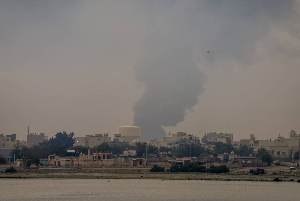 A plume of smoke rises after a reported Iranian strike on fuel tanks in Muharraq on March 12, 2026. - (Photo by FADHEL MADHAN / AFP)