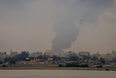 A plume of smoke rises after a reported Iranian strike on fuel tanks in Muharraq on March 12, 2026. - (Photo by FADHEL MADHAN / AFP)