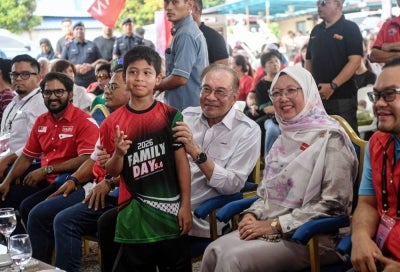 Prime Minister Datuk Seri Anwar Ibrahim (centre), who is also Pakatan Harapan chairman, poses for a photograph upon arriving at the Ramah Mesra Bersama PMX programme. BERNAMA photo.