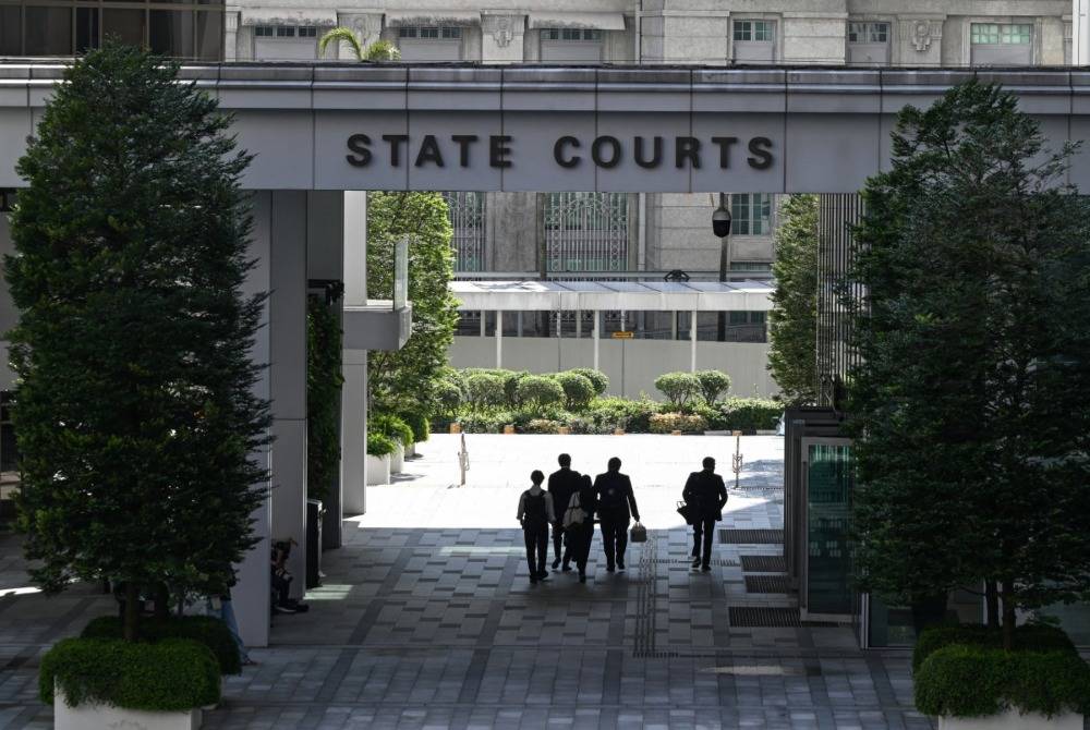 People walk through the State Court building in Singapore on June 26, 2026. - (Photo by ROSLAN RAHMAN / AFP)