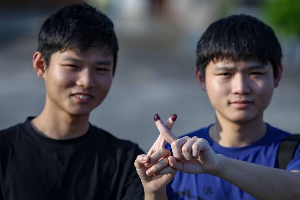 (Illustrative Purposes) Twin brothers Tan Kai Sheng (right) and Tan Ye Sheng show their ink-stained fingers after casting their votes at the Sekolah Kebangsaan Seri Melati polling centre during the 16th Johor State Election today. (BERNAMA PHOTO)