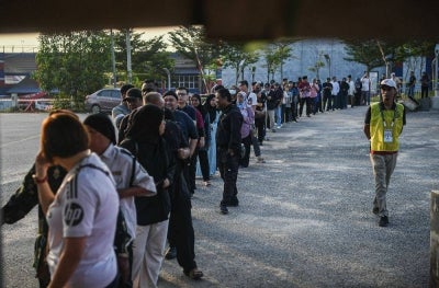 People wait their turn to vote for the N.44 Larkin state seat in the 16th Johor State Election (PRN Johor) at Sekolah Kebangsaan Tanjung Puteri today. Photo by Bernama