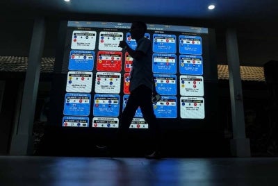 A screen displaying the latest results of the 16th Johor state election at the Johor Umno Liaison Committee headquarters in Johor Bahru, today. - Bernama Photo