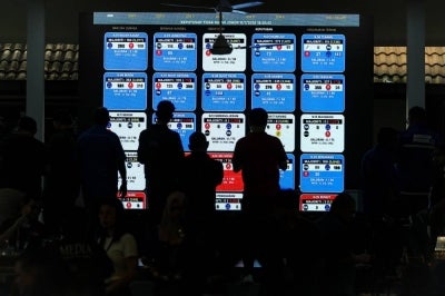 Some of the party members looking at the screen showing the results of the Johor state election at the Johor Umno Liaison Committee headquarters in Johor Bharu, today. - Photo by Bernama